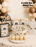 A Little Boo Is Almost Due Halloween baby shower setup featuring ghost decorations, baby shower favors, cupcakes, and neutral fall decor