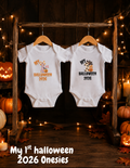My First Halloween Onesies 2026 baby Halloween bodysuits displayed on wooden hangers with pumpkins and Halloween lights